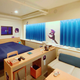 A wide shot of the Unreal Life hotel room shows controllers.